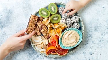 Mother sharing healthy vegan dessert snacks with toddler child.