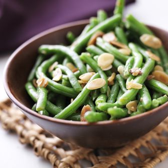 close up photo of a bowl of green beans with almonds