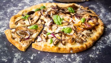 kaaspizza met Grana Padano, paddenstoelen en basilicum