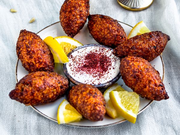 liggend beeld kibbeh met yoghurtdip en citroen