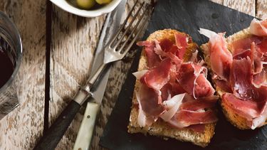 Delicious appetizer of spanish ham and salad, on rustic table