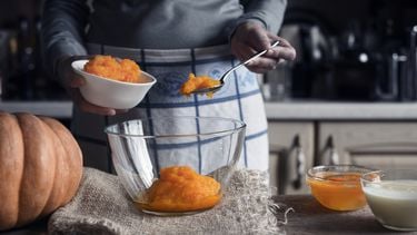 pompoenpuree Putting pumpkin puree in the glass bowl horizontal