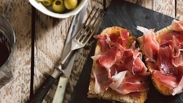 Delicious appetizer of spanish ham and salad, on rustic table