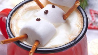 Red mug with hot chocolate with melted marshmallow snowman