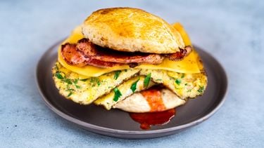 Breakfast sandwich op een scone met spek, kaas en omelet