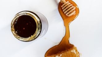 Een pot met echte honing / rauwe honing / honingraat